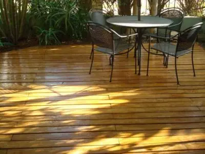 Área externa com deck de madeira e mesa