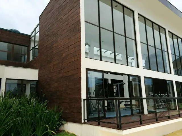 Fachada comercial revestida em madeira com esquadrias de vidro