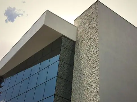 Fachada contemporânea combinando pedra e vidro